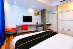 a bedroom with a bed and a desk and a tv at Collection O Near Tanjung Batu Formerly 4orty Inn in Bintulu