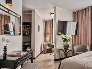 a hotel room with a bed and a table with flowers at Dethloff Art Residence in Warsaw