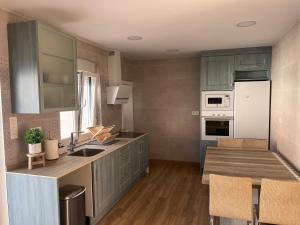 a kitchen with gray cabinets and white appliances at Villa Calhia in León