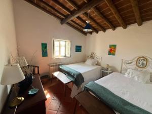 a bedroom with two beds and a table with a lamp at Courela da Anta in Vimieiro +55 photos