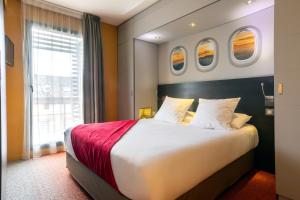 a hotel room with a large bed with two windows at Appart Hôtel Clément Ader in Toulouse +49 photos