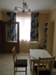 a dining room with a table and chairs and a window at Kiserdő Vendégház in Rajka