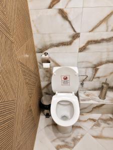 a white toilet in a bathroom with marble walls at Apartment Be Happy 6, Premium Apartment in Ruse City Centre in Ruse +37 photos
