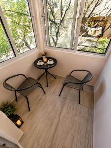 a room with two chairs and a table and two windows at Apartment Be Happy 6, Premium Apartment in Ruse City Centre in Ruse