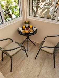 a table with a plate of food and two chairs at Apartment Be Happy 6, Premium Apartment in Ruse City Centre in Ruse