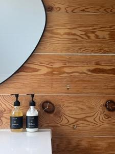 two bottles of soap on a counter next to a mirror at Fjord House Hardanger in Grimo