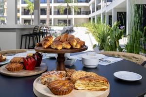 a table with a bunch of pastries and muffins on it at La Finestra in Nydri