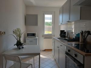 a kitchen with white cabinets and a table and chairs at Ferienwohnung Karl 54 in Gelenau