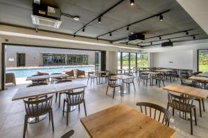 a restaurant with tables and chairs and a pool at Spacious 2-Bedroom Family Suite with Pool & Garden View in Moka