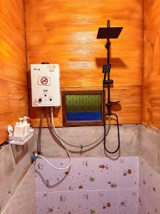 a shower in a wooden room with a sink and aperature at กินลมชมจันทร์ แม่กำปอง in Ban Pok Nai