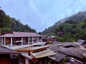 a group of buildings with mountains in the background at กินลมชมจันทร์ แม่กำปอง in Ban Pok Nai