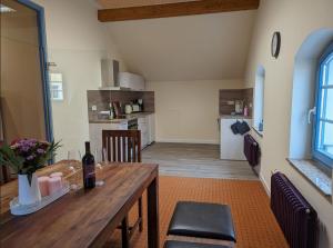 a kitchen and dining room with a wooden table at Ferienwohnung Zur Kirschallee in Hochkirch +7 photos