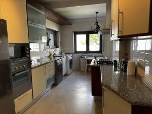 a large kitchen with a sink and a stove at Cascais House - Pool in Parede +15 photos
