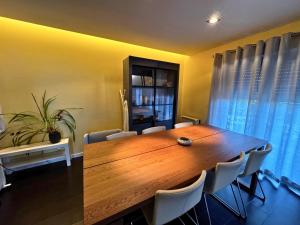a dining room with a wooden table and chairs at Cascais House - Pool in Parede