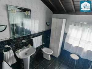 a bathroom with a sink and a toilet at Nandes Place in Praia da Vitória +22 photos