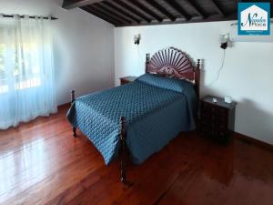 a bedroom with a bed with a blue comforter at Nandes Place in Praia da Vitória