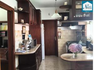a kitchen with a table with a vase of flowers at Nandes Place in Praia da Vitória