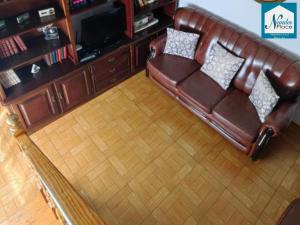 a brown leather couch sitting in a living room at Nandes Place in Praia da Vitória
