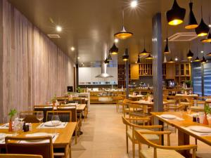 a dining room with wooden tables and chairs at The Park Hotel in Phitsanulok
