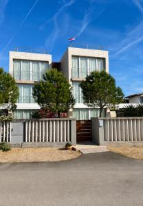 a white fence in front of a building at St.Barth Apartments in Šibenik
