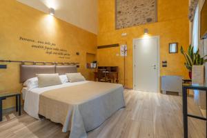 a bedroom with a bed in a room with yellow walls at Borgo Petrarca in Arquà Petrarca +40 photos