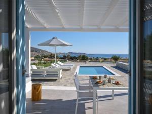 a patio with a table and a swimming pool at Blue Mare Villas in Naousa