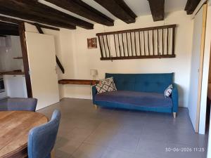 a living room with a blue couch and a table at Gîte Chevannes - Holiday home - Pool - Parking - Mobility friendly - Pets welcome in Fours