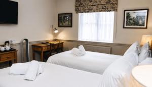 a hotel room with two beds and a window at George Inn, Mere in Mere +85 photos