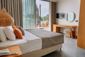 a hotel room with a bed and a desk at Yalıpark Beach Hotel in Yalıkavak