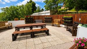 a patio with benches and a table and a fence at Logicoeur in Gérardmer