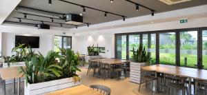 a restaurant with tables and chairs and plants at Spacious 2-Bedroom Family Suite with Pool & Garden View in Moka
