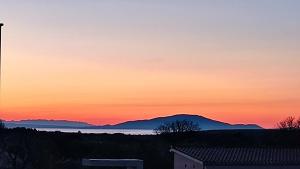 a sunset over the water with mountains in the background at Apartment Istra Mare private pool & parking in Ližnjan