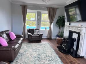 a living room with a couch and a fireplace at Cheerful cottage 3-bedroom in Drehidnaraga Bridge