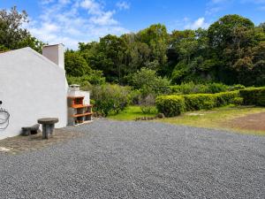 a gravel driveway with a bench next to a building at Pico Island Villas 117 - Natural Pools and Incredible Views in São Roque do Pico