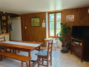 a living room with a table and chairs and a television at Domaine De Vic in Saint-Chamassy