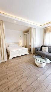 a bedroom with a bed and a couch and a table at Royal Lea Apartmens in Netanya