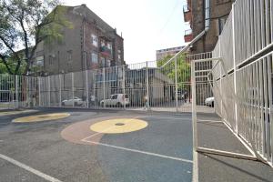 a gate with a basketball court in a parking lot at Old Yerevan Guesthouses in Yerevan