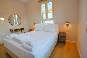 a bedroom with a white bed with towels on it at Makaros Nissos City in Mytilene