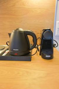 a tea kettle and a phone on a table at Makaros Nissos City in Mytilene