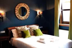 a bedroom with a bed with a mirror on the wall at Friars Wynd Guest Rooms in Stirling