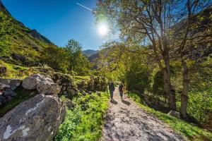 two people walking down a dirt road at Casa del Tesoro II in Cangas de Onís