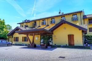 a yellow building with a car parked in front of it at Hotel Ristorante Vecchia Riva in Varese