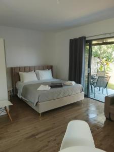 a bedroom with a bed and a sliding glass door at Mediterranean Studio Ratzakli in Ratzaklíon +29 photos