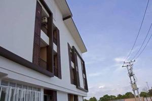 un edificio blanco con persianas marrones en él en Field Town Apartment, en Nakhon Nayok