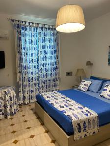 a bedroom with a blue bed and a blue curtain at villa martina suite apartament in Lacco Ameno