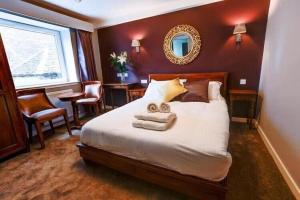 a hotel room with a bed with towels on it at Friars Wynd Guest Rooms in Stirling +16 photos