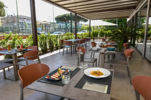 a restaurant with tables and chairs with food on them at Petit Hotel in Caorle