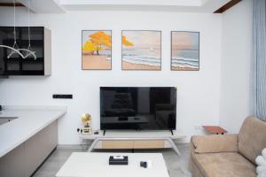a living room with a large flat screen tv at Juney Villas Zanzibar in Zanzibar City