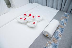 a bed with white towels and flowers on it at Juney Villas Zanzibar in Zanzibar City +73 photos