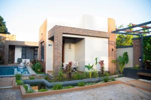 a house with a swimming pool in front of it at Juney Villas Zanzibar in Zanzibar City